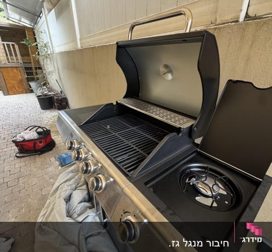 גריל גז עם כיסוי פתוח בחצר